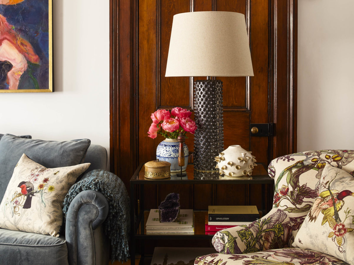 corner of vintage eclectic living room with silver lamp and floral chair