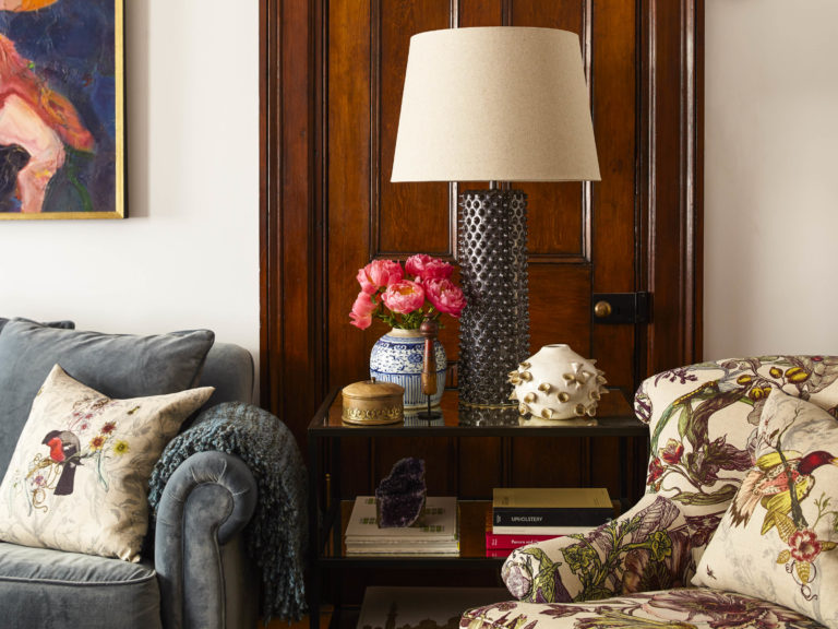 corner of vintage eclectic living room with silver lamp and floral chair