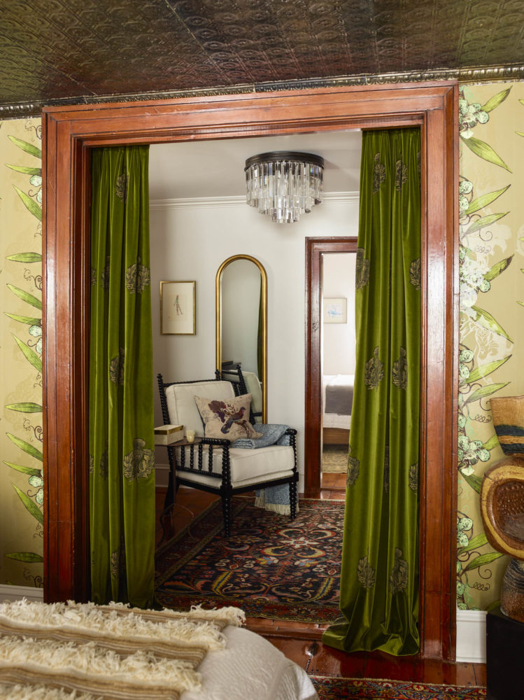 green velvet curtains leading to vintage sitting room